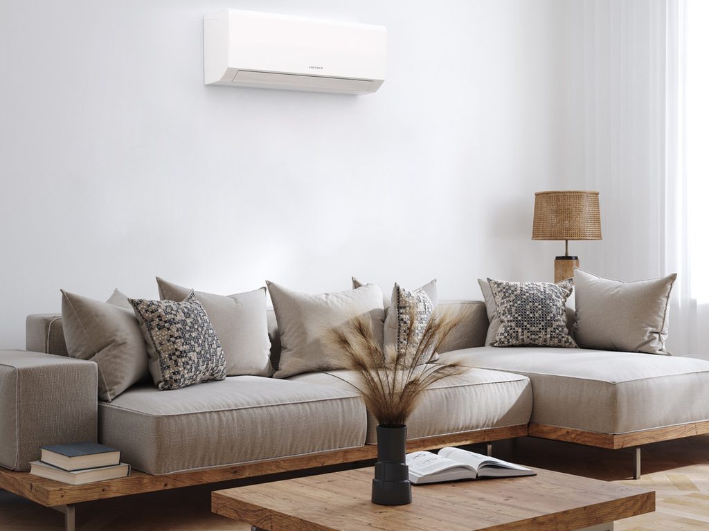 Wandmodel airco boven een zithoek in een leefruimte